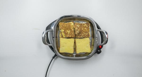 Erste Seite der Toasts braten, bis das Brat-Fenster wieder erreicht ist. Toasts wenden und ohne Deckel ca. 3 Minuten gold-braun fertig braten.