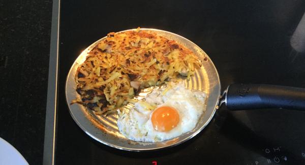 Rösti etwas zusammenschieben, den Butter zugeben und im freien Platz die zwei Eier aufschlagen. Hitze ausschalten (Induktion Stufe 4) und das Spiegelei nach Wunsch braten und würzen. Rösti halbiert auf zwei Tellern anrichten, je ein Spiegelei darauf geben und servieren. Dazu passt ein frischer Saisonsalat.