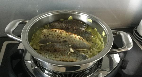 Nach Ablauf der Garzeit, das  Gemüse abschmecken und mit Butterflocken verfeinern. Den grillierten Fisch mit der Hautseite nach oben auf das Gemüse legen. Den fertig angerichteten Fisch-Gemüsereis-Topf im umgekehrten Servierdeckel zu Tisch bringen und servieren.