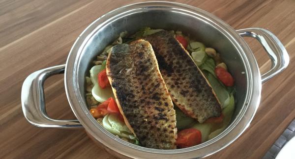 Den Fisch auf das Gemüse betten und im umgekehrten Servierdeckel zu Tisch bringen. Auf vorgewärmten Tellern servieren.