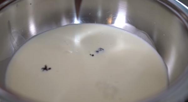 Die Sahne und 100ml von der Milch in die Sauteuse geben. Das Mark der Vanilleschote auskratzen und das Mark und die Schale in die Sauteuse ebenfalls geben.