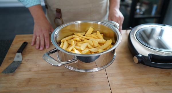 Sobald das Fleischsymbol erreicht ist, die Pommes in den Topf legen und den Topf in den Servierdeckel stellen.