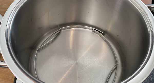 Ein Glas Wasser (ca.200ml) in den 6,5 Liter Topf gießen. Anschließend die Bügel vom Softieraeinsatz in den Topf legen.