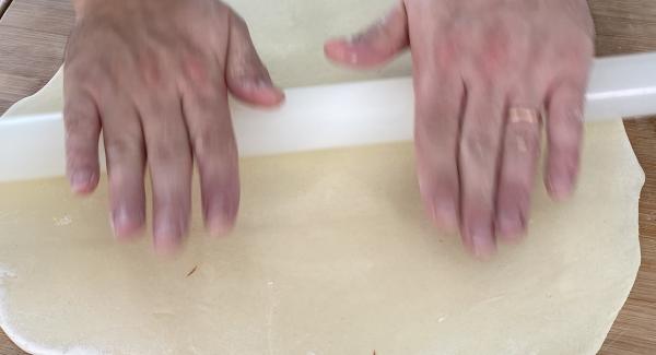 Den Teig mithilfe eines Teigroller dünn ausrollen.