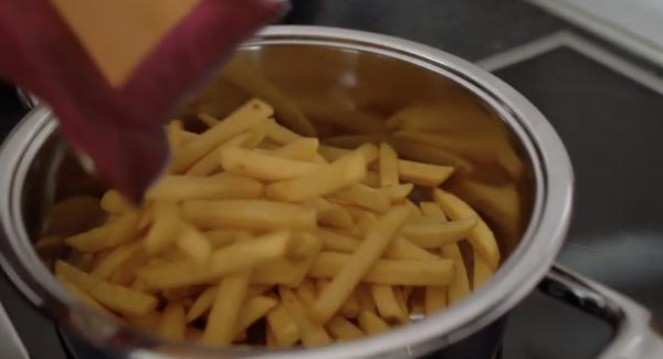 Die 600g Pommes in den Topf tun und gleichmäßig verteilen.