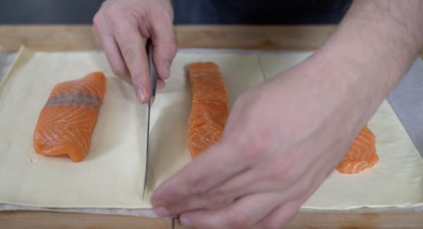 Den Blätterteig ausrollen. Die Lachsfilet-Stücke auf den Blätterteig legen und den Blätterteig in 3 große Stücke schneiden. Den Lachs gut salzen.&nbsp;