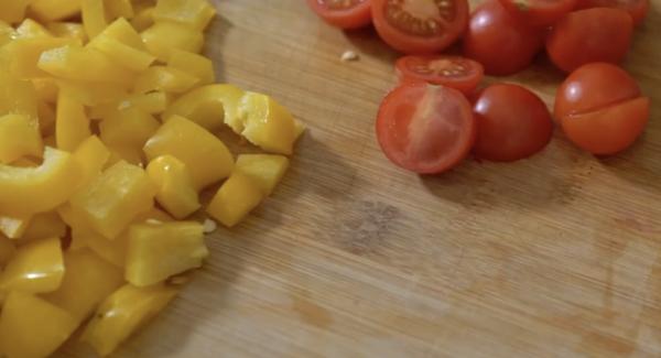 Zwei Paprikaschoten kleinschneiden. Danach die 150g Kirschtomaten halbieren.