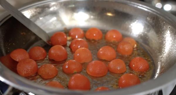 Die Kirschtomaten mit der angeschnittenen Seite in die Hotpan legen.