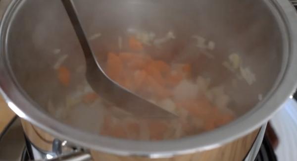 Die Zwiebeln und Möhren direkt in den kalten Topf geben und leicht anbraten lassen.