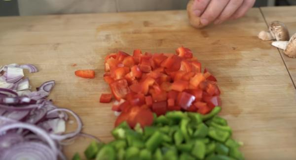 Zwei Zwiebeln in Scheiben schneiden. Zwei Paprika in Würfel schneiden. ca. 150g Champignons kleinschneiden.