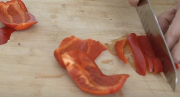 Zwei Paprika in Scheiben schneiden.