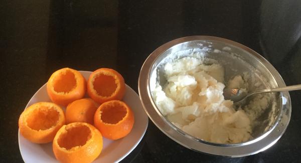 Zum Servieren das Sorbet mit dem Pürierstab geschmeidig mixen. In die gefrorenen Mandarinenschalen füllen, den Deckel wieder aufsetzen (kann auch weggelassen werden). Auf Dessertteller oder auf Platte stellen, mit Puderzucker bestäuben und mit Mandarinenbüten und-Blätter dekoriert, sofort servieren.