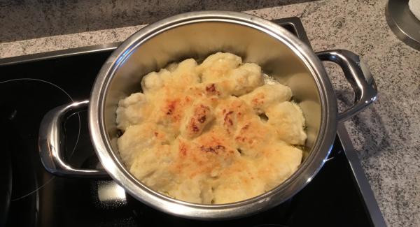 Die fertigen Klösschen in den leeren, ausgespühlten Topf legen.
Den Rest des geriebenen Käses darüber streuen. 
Mit Navigenio auf Stufe 2 während 9 Minuten überbacken.