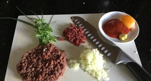 Hirschfilet und Bündnerfleisch von Hand mit dem Santoku Messer mittelfein hacken. Zwiebeln, Knoblauch und Schalotte im Quick Cut fein hacken. Ebenfalls die Petersilie und den Schnittlauch