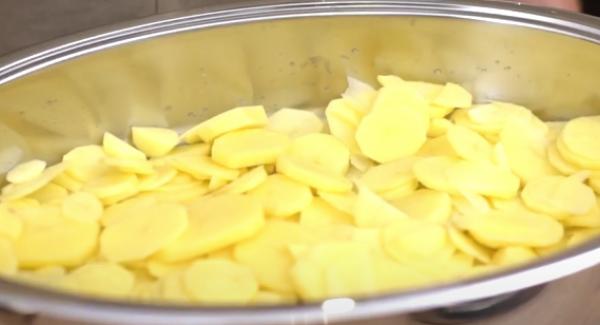 Die Kartoffelscheiben in den Bräter geben. Anschießend die Kartoffeln gut mit Salz würzen.