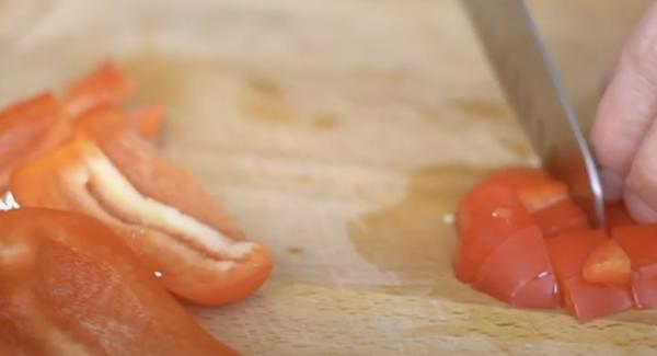 Eine Paprika in Würfel schneiden.