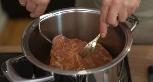 Das marinierte Fleisch in den Topf legen.