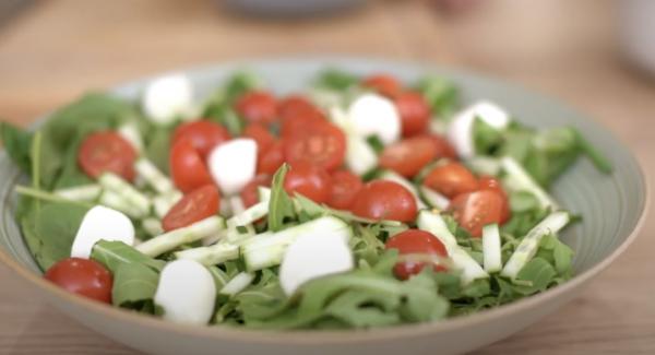 In eine Schale eine Portion Blattspinat, eine Portion Feldsalat, eine Portion Rucola, 100g halbierte Cocktail Tomaten und 100g Mozzarella-Bällchen.