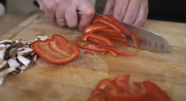 Eine Paprika in Streifen schneiden.