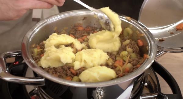 Den Kartoffelbrei auf das Hackfleisch geben.