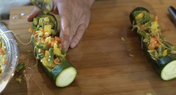 Die Zucchini mit dem Gemüse befüllen.