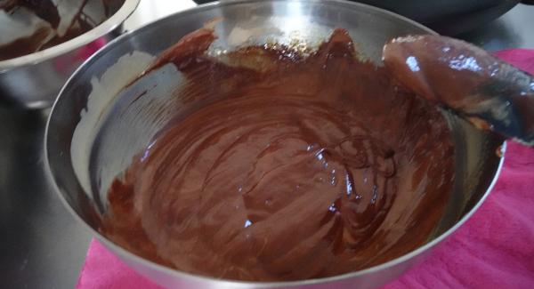 Schokoladen-Buttermasse langsam unter die Eimasse heben.