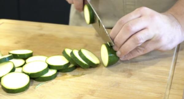 Zwei Zucchini in Scheiben scheiden.