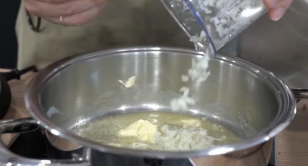Sobald die Butter zerschmolzen ist, eine gehackte Zwiebel dazugeben.