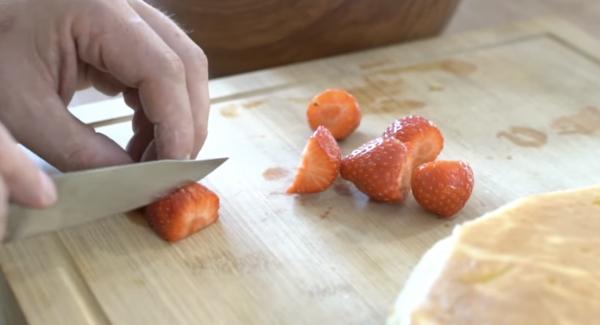 Als nächstes eine Handvoll Erdbeeren in Würfel schneiden.