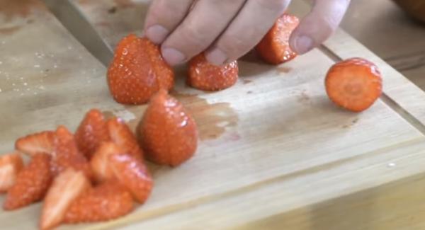 Die restlichen Erdbeeren vierteln. Zum Schluss noch Puderzucker drüber geben.