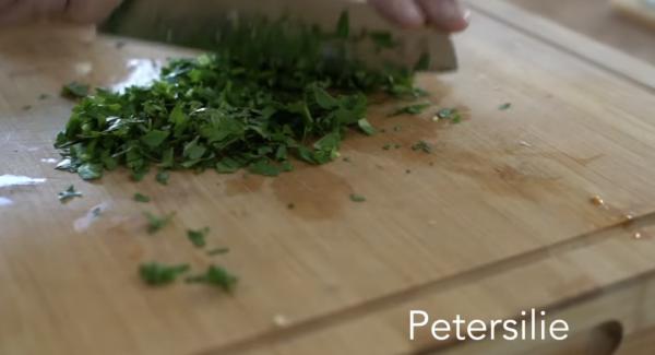 In der Zwischenzeit können die 100g Kirschtomaten halbiert werden. Anschließend die Petersilie und den Basilikum klein hacken. Zum Schluss kann der Parmesan gerieben werden.