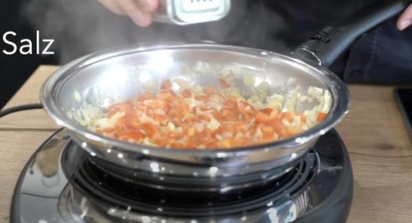 Sobald die Zwiebeln leicht glasig sind, die Paprika hinzugeben und alles gut salzen.
