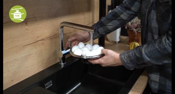 Wenn in der Zwischenzeit die Eier fertig sind, Eier mit kaltem Wasser abschrecken, anschließend schälen und halbieren.