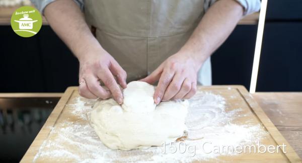 Nach dem sich die Teigmenge verdoppelt hat, den Teig noch eimal an den 'Ecken' ziehen und den Camembert hinein arbeiten. Dann noch einmal 30 min gehen lassen und nicht mehr kneten.