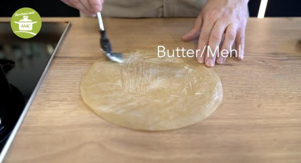 In der Zeit fetten wir das Backpapier leicht mit Butter ein und bemehlen es etwas.