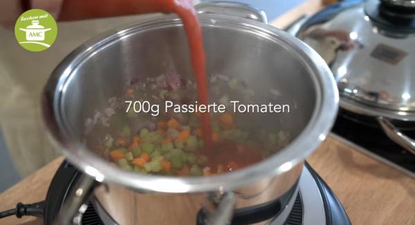 Mit 700 g passierten Tomaten und der Gemüsebrühe ablöschen.