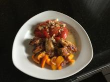 Pouletflügeli grilliert auf Paprikagemüse mit Tomatensalat